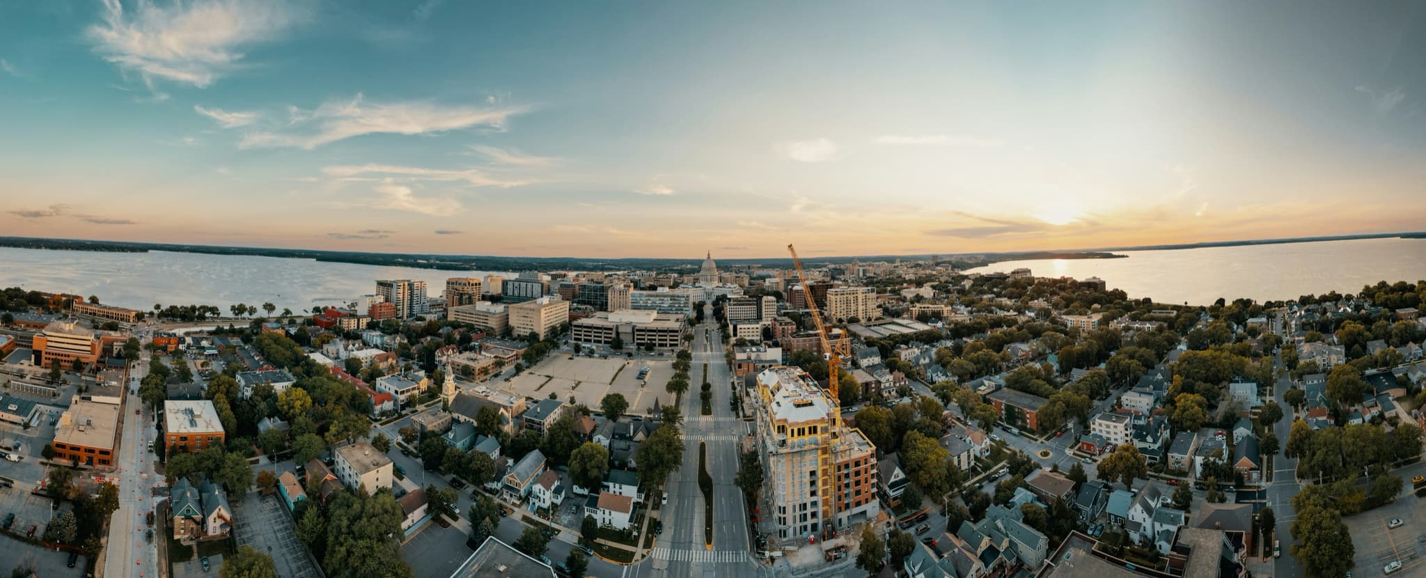 Aerial view of downtown Madison, Wisconsin at sunset, looking down the isthmus toward the Capitol between Lake Mendota and Lake Monona