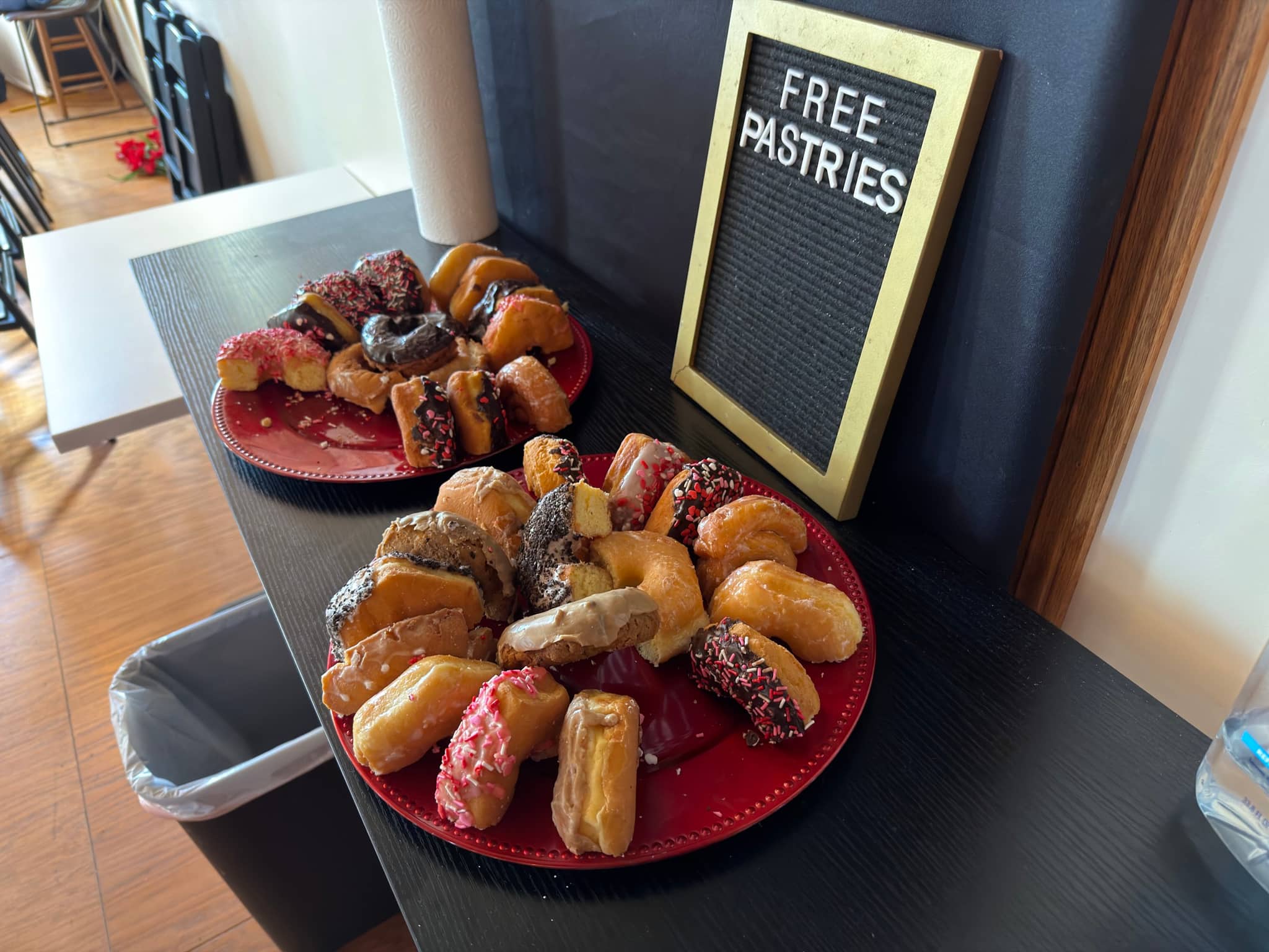 A tray of free pastries beside a letter board reading Free Pastries at New Culture Church on a Sunday morning