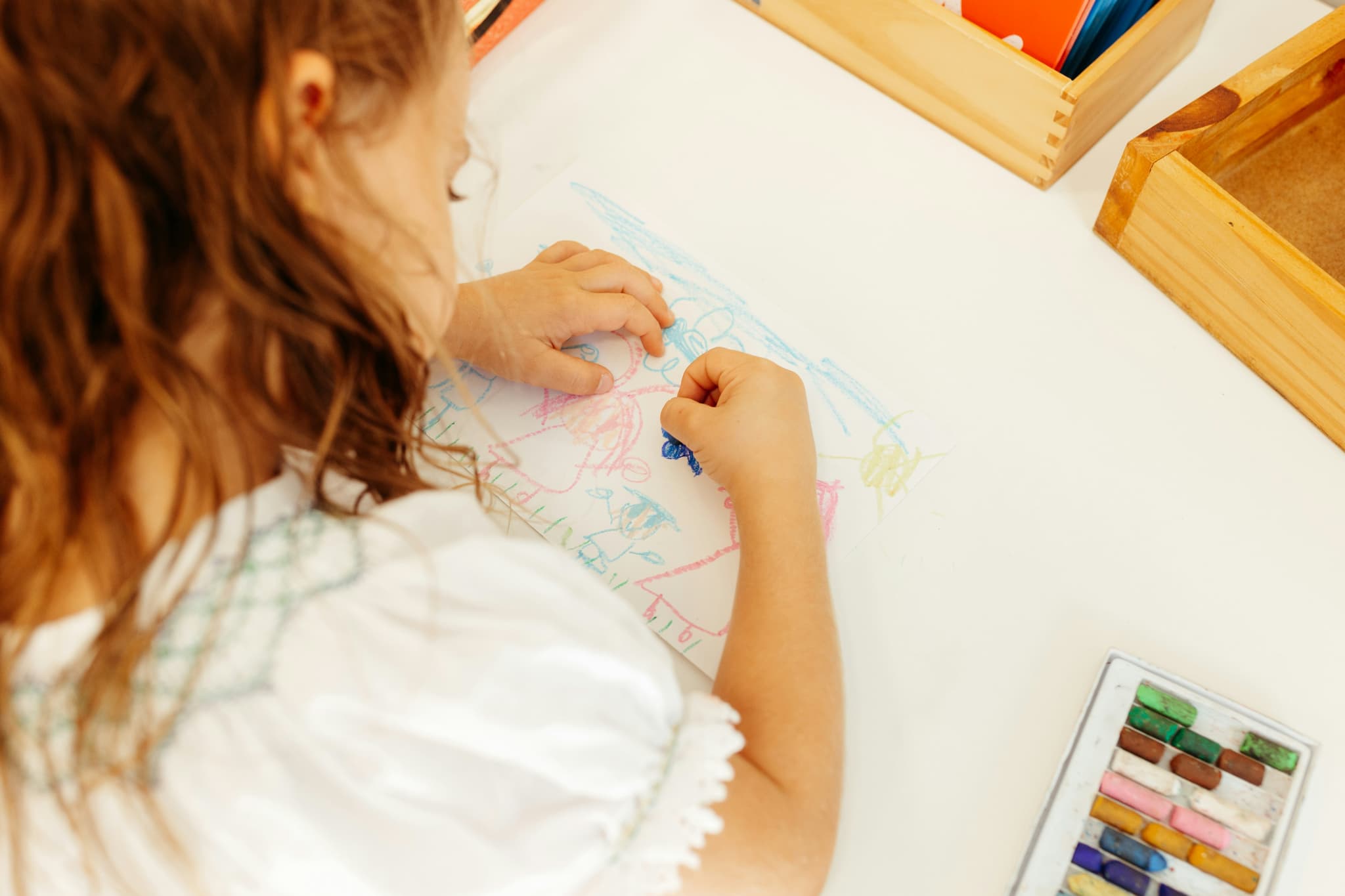 A child drawing with crayons at a table during kids' time at New Culture Church in Madison, Wisconsin