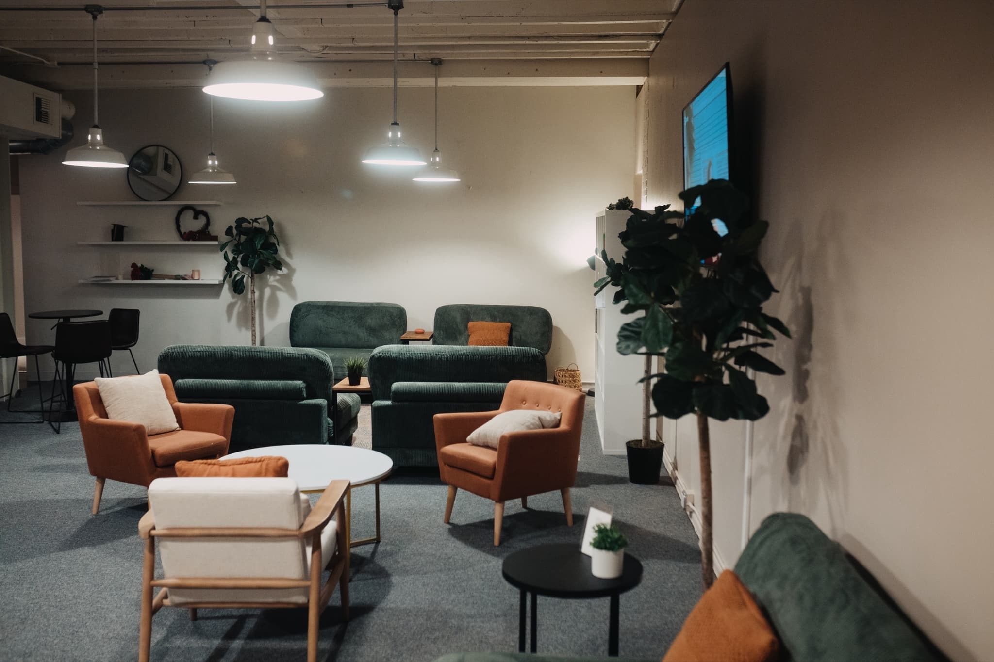 Rust armchairs and low tables in The Living Room, arranged for conversation