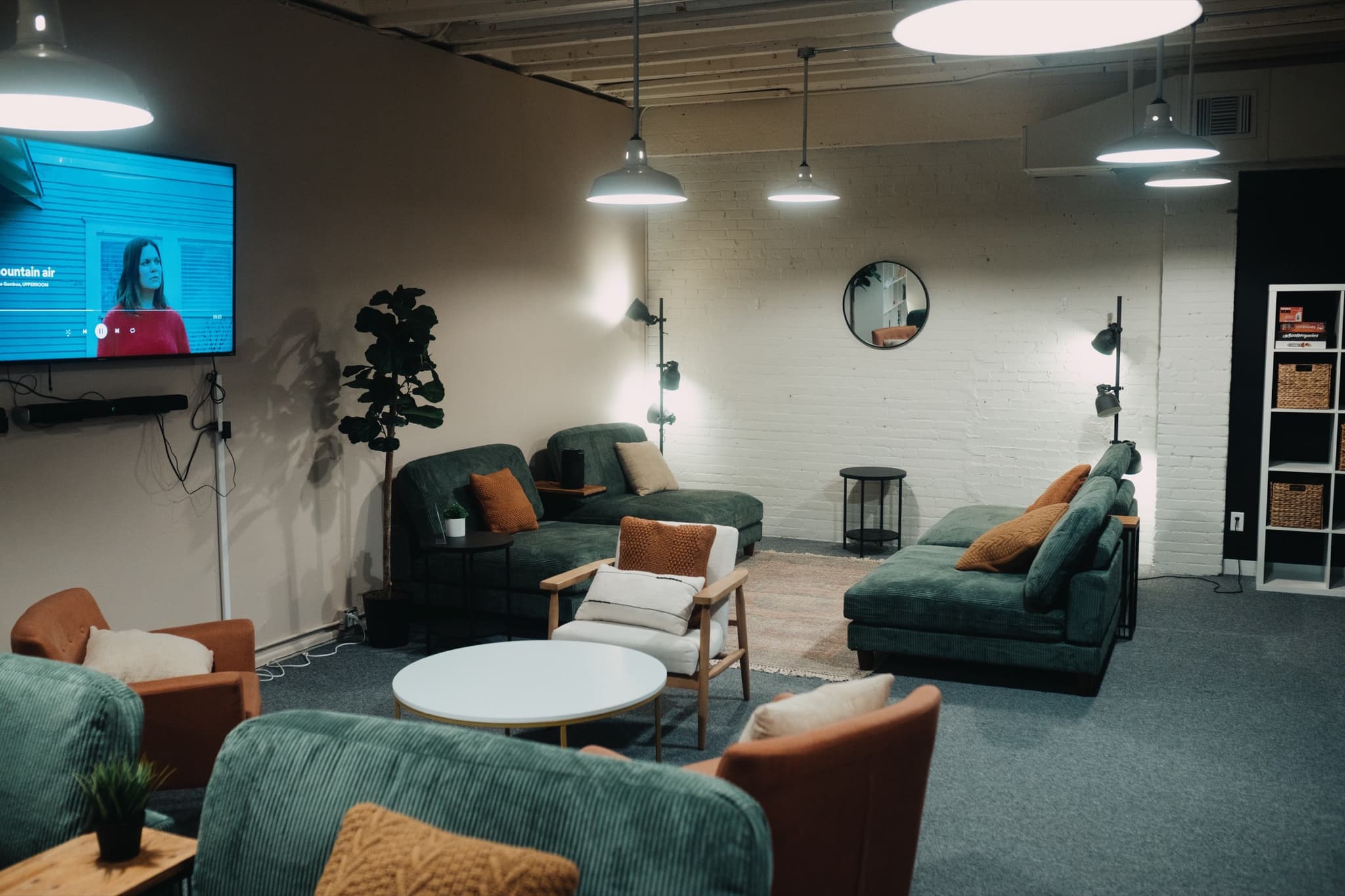 The Living Room set up as a coworking lounge with armchairs and round tables in Madison, WI