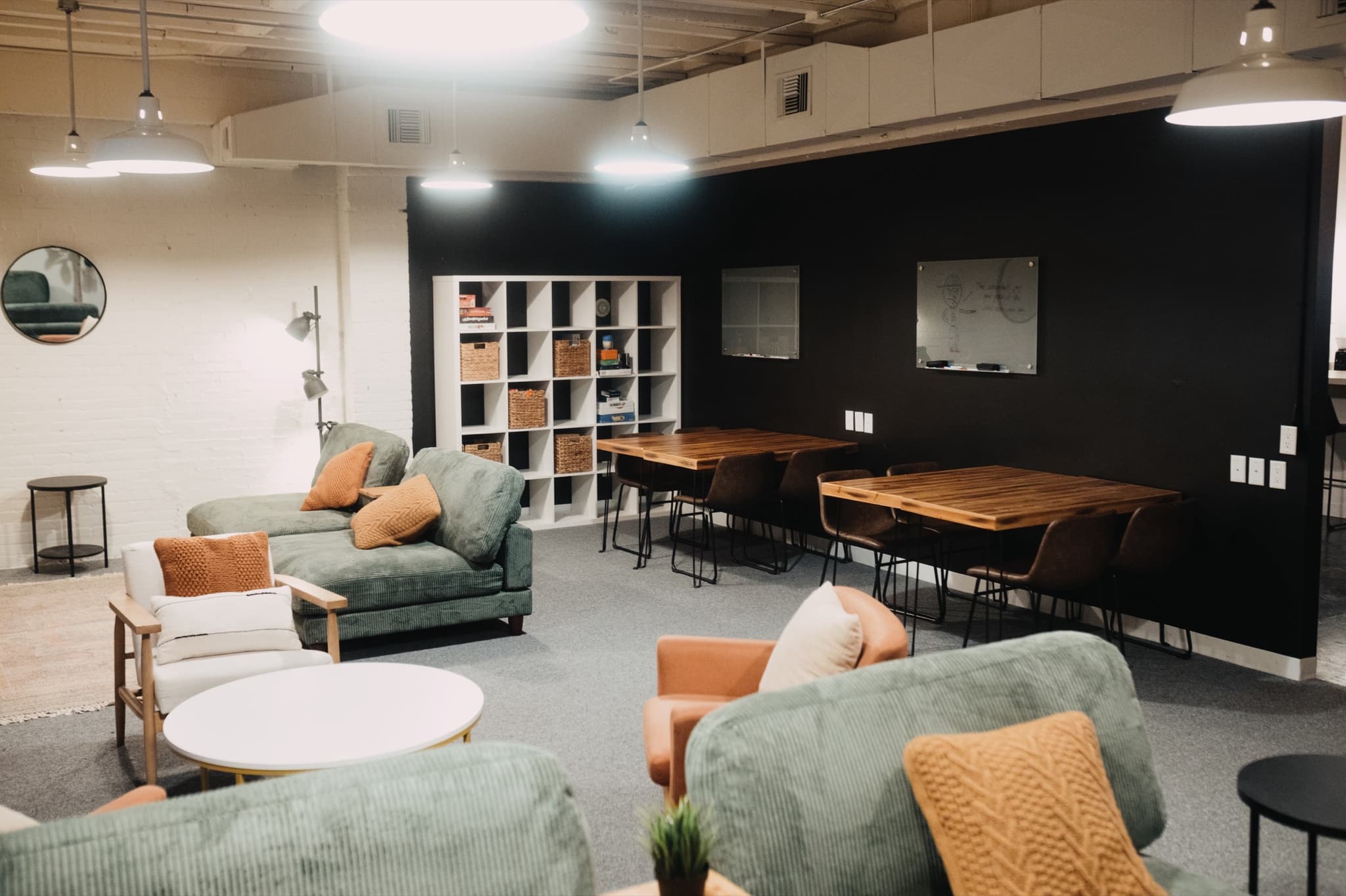 Wood-topped work tables and lounge seating in The Living Room, set up for coworking